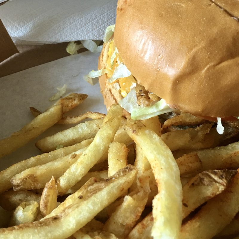 A burger and chips in a takeaway box
